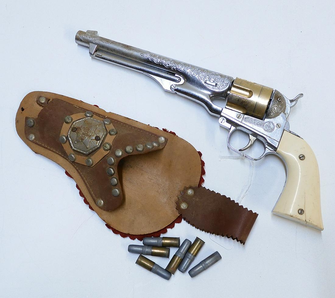 1960's Hubley 14" long barrel six shooter with generic: 1960's Hubley 14" long barrel six shooter with generic holster. Gun is faux chrome style with gold colored revolver section and white plastic handles, in working order. Single gun cradle does not have