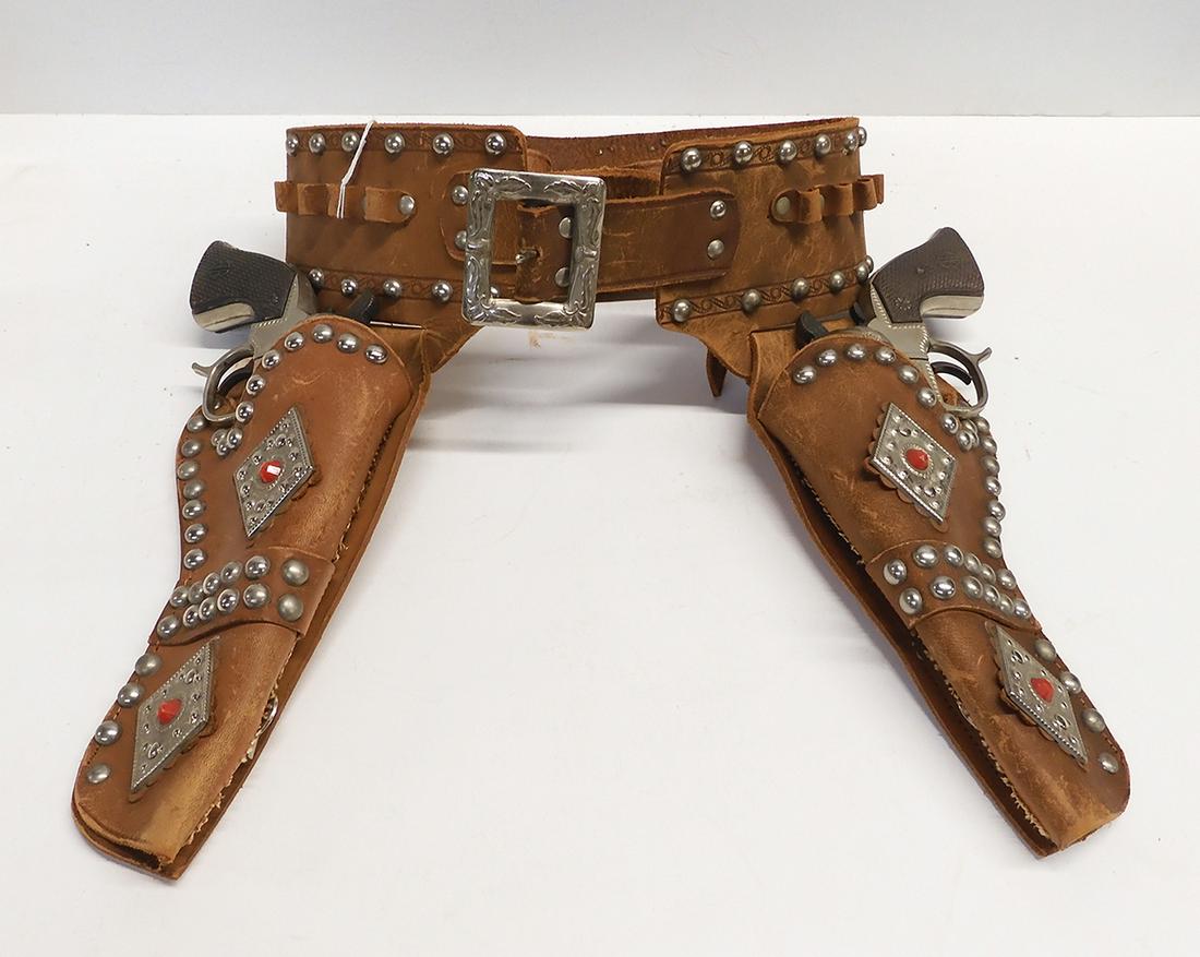 A pair of 1950's Buck'n Bronc Cowhand cap guns with: A pair of 1950's Buck'n Bronc Cowhand cap guns with holsters . Both guns are operational.