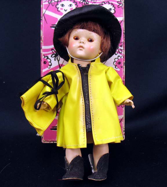 Vogue Strung Ginny, tagged raincoat, hat, boots, p: Vogue strung Ginny wearing tagged yellow raincoat and black hat, black boots, yellow plastic matching purse, hard plastic, in box, C. 1953