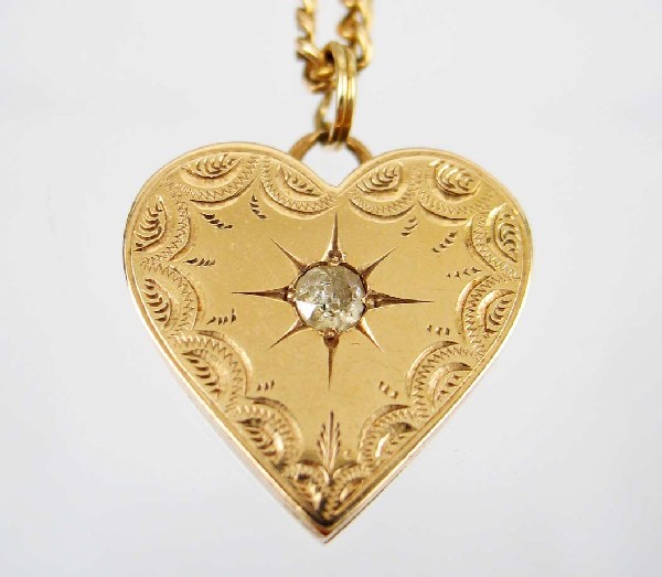 Gold and diamond heart locket with chain, 14k yell: Gold and diamond heart locket with chain, 14k yellow gold locket set with mine cut diamond measuring approximately 20 points, engraved design on border, locket measures 7/8" long x 7/8" wide, interior