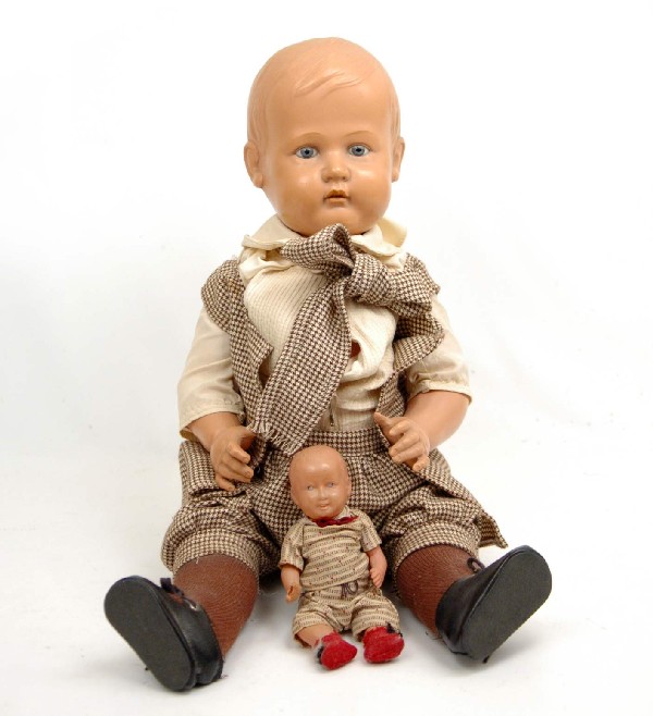 German celluloid boy doll, 23", wearing brown chec: German celluloid boy doll, 23", wearing brown checked pants and vest, blue open eyes and 7" celluloid boy doll