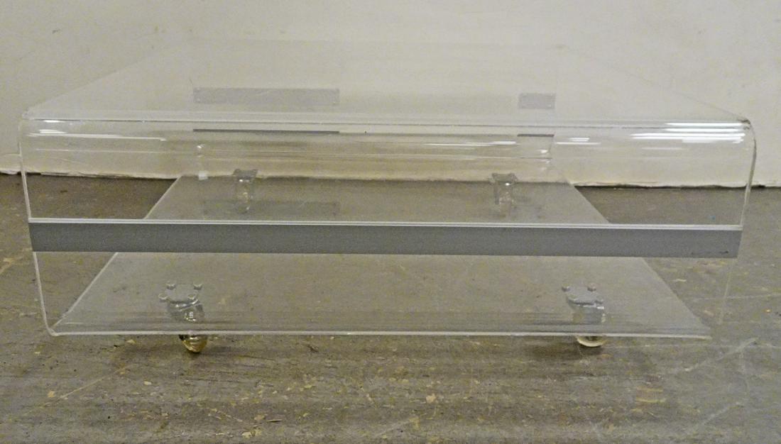 Modernistic Lucite Low Table: Modernistic style Lucite low table on four castors, manufacturer unknown, circa 1970's, 12 1/2" (height) x 27" (length) x 27" (width)