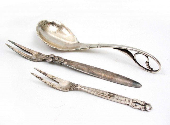 Three Danish sterling flatware pieces including tw: Three Danish sterling flatware pieces including two Georg Jensen lemon forks 4 5/8" and 6", and a sterling spoon 5 3/4", impressed Sterling Denmark, 2.371 oz. (troy) total weight, mid 20th C.