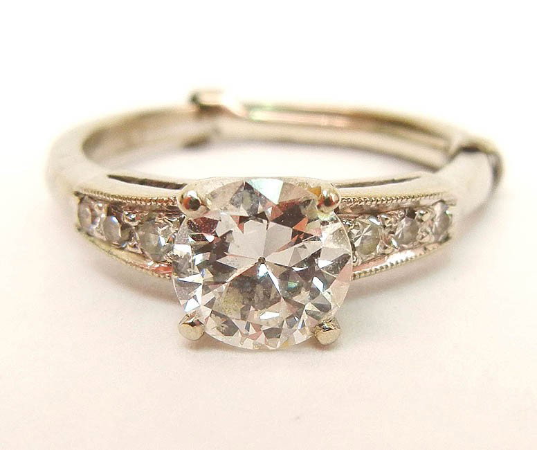 Diamond solitaire engagement ring in 14k white gol: Diamond solitaire engagement ring in 14k white gold setting, transitional cut round center stone measures approximately 100 points or 1 carat, color I-J, clarity I-1, three small diamond accents on ei