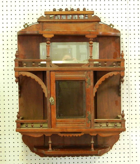 Walnut hanging what-not shelf, stick and ball corn: Walnut hanging what-not shelf, stick and ball cornice and galleries, beveled mirrored splashback, centered beveled glass door, late 19th C., 36" high x 24" across x 7" deep