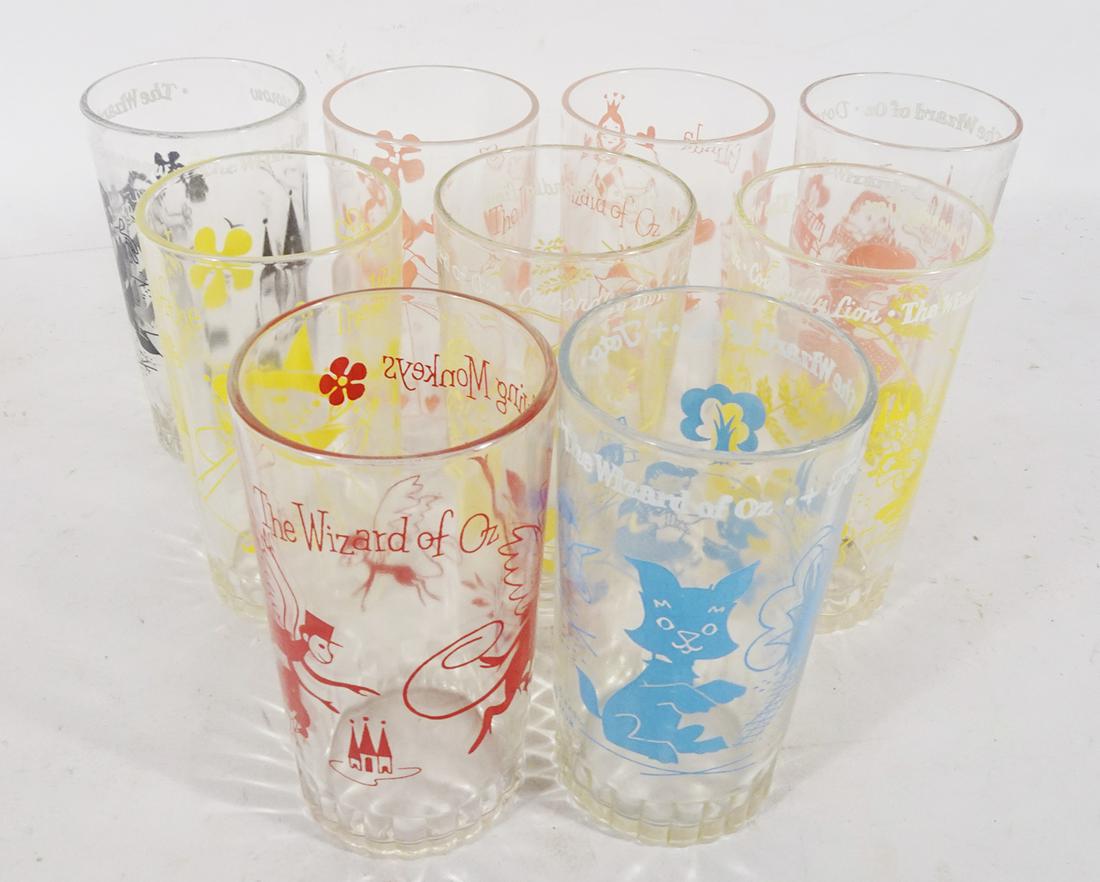 Nine 1950's Wizard of OZ premium tumblers.: Nine 1950's Wizard of OZ premium tumblers. Lot consists of two Glinda the Good Witch tumblers (pink print), Witch of the North (yellow print), two Cowardly Lion (yellow print), Scarecrow (black print)