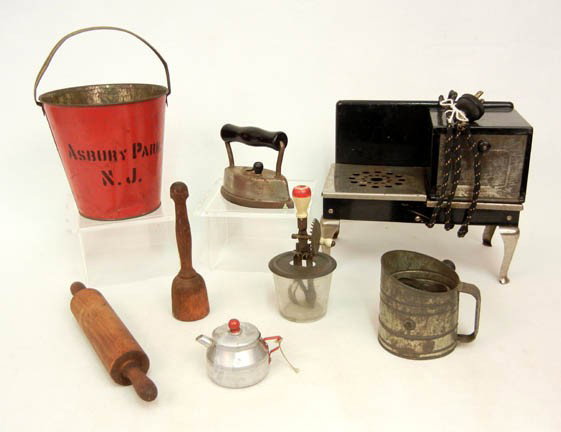 Grouping of toy kitchenwares including electric : stove, tin flour sifter, wooden masher and wooden rolling pin, beater, sad iron, and a tin teapot, also included is a tin sand pain stenciled Asbury Park N.J.