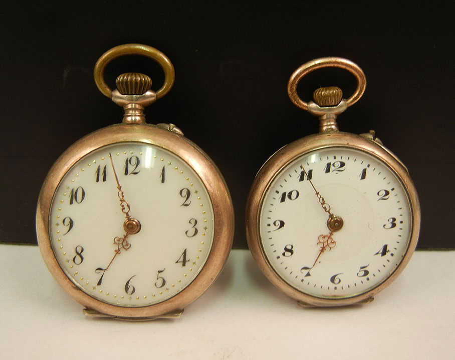Two pocket watches with similar design on cases, b: Two pocket watches with similar design on cases, both with .800 silver cases and partial gold wash, open face, larger watch is 1 1/4" in diameter, smaller watch is 1 1/8" diameter, both dust covers ma