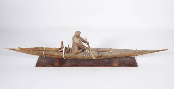 Eskimo Inuit Kayak Model: Eskimo Inuit kayak model, sealskin covered kayak with a removable sealskin covered male figure that has carved wood face and hands, bone mounts on oar paddle, harpoon and kayak, sits onto a wood base