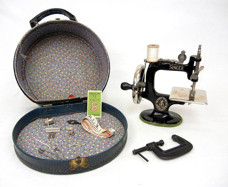 Child's Singer sewing machine in carrying case wit: Child's Singer sewing machine in carrying case with thread, needles, clamp, thimble, and measuring tape