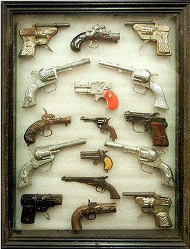 Shadow box display case with sixteen toy guns: Shadow box display case with sixteen toy guns, including Derringer, Smoky, and Pearl, 17" high x 13 1/8" across x 1 3/4" deep