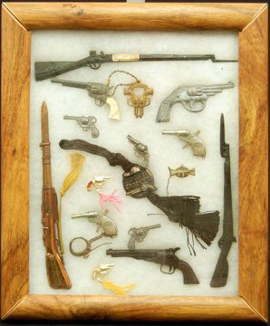 Shadow box display case with thirteen toy guns: Shadow box display case with thirteen toy guns, two gun medallions, and a Davy Crockett medallion, including Molgora, 14" high x 12" across x 1 1/2" deep