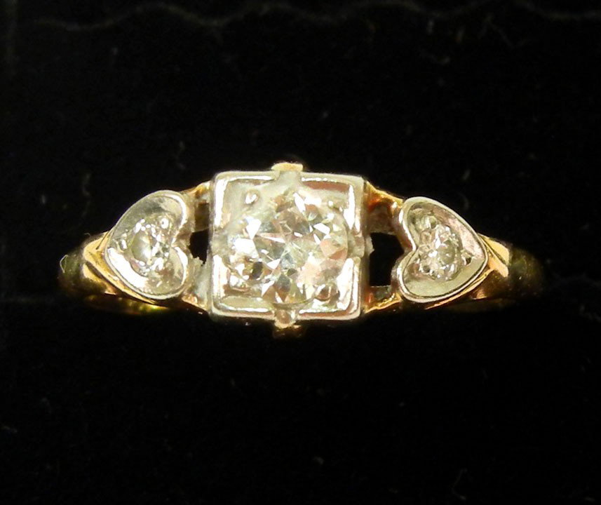 Gold and platinum diamond solitaire engagement rin: Gold and platinum diamond solitaire engagement ring, center round European cut diamond measures approximately 35 points, heart motif on either side set with one point diamond, size 6 3/4, marked plati