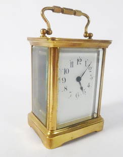 French Miniature Travel Carriage Clock: French miniature travel carriage clock, brass cased with glass panels, enameled porcelain clock face with Arabic numerals, signed on verso back panel "Made in France", circa mid 20th c., 5 1/4" (h) x