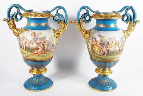 Pair of Sevres Style Paris Porcelain Urns: Pair of Sevres style French Paris porcelain urns, turquoise glazed, hand painted gilt overlay, floral designs and scenic design with Putti and goats, double serpent form handles, both are unsigned,