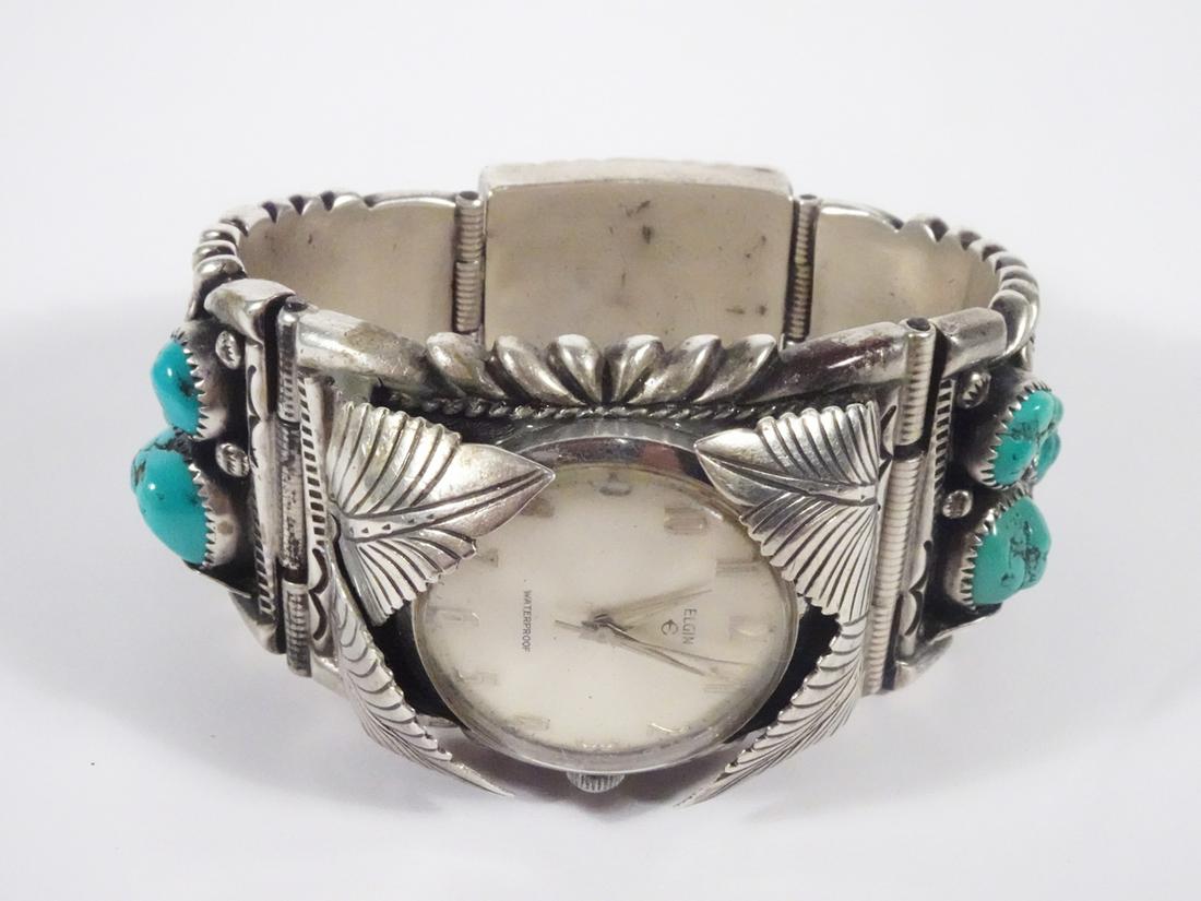Elgin Watch Turquoise Silver Band: Elgin Watch Turquoise Silver Band, signed: RW James (Navajo); linked sterling contoured bracelet with hidden tongue closure; approx. 7" length; With: 44-25mm tapering in back; Set with ten pieces of t