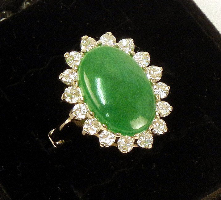 Gold, jade and diamond ring, 10k white gold mounti: Gold, jade and diamond ring, 10k white gold mounting, adjustable size, oval green jade measures 16mm long x 11mm wide, surrounded by sixteen round 10 points diamonds, unmarked, tests 10k, weight 7.9 g