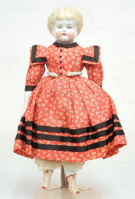 China head doll, painted eyes and closed mouth, mol: China head doll, painted eyes and closed mouth, molded and painted hair, cloth body, china arms and legs, molded and painted boots, dressed in older clothes, 9 1/2"