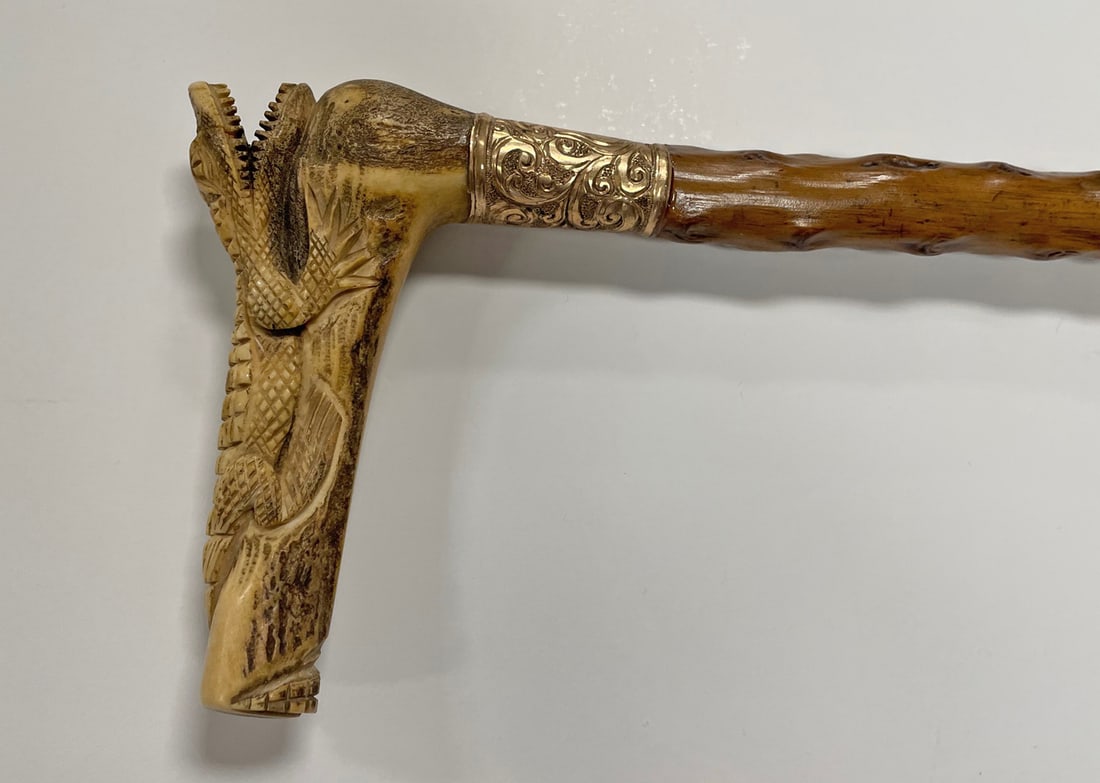 Folk Art Style Figural Handle Cane: Folk art style figural handle cane, carved bone Alligator form handle above a gold plated mount, carved natural wood shaft, applied brass tip at end, circa early 20th c., 32 1/4"