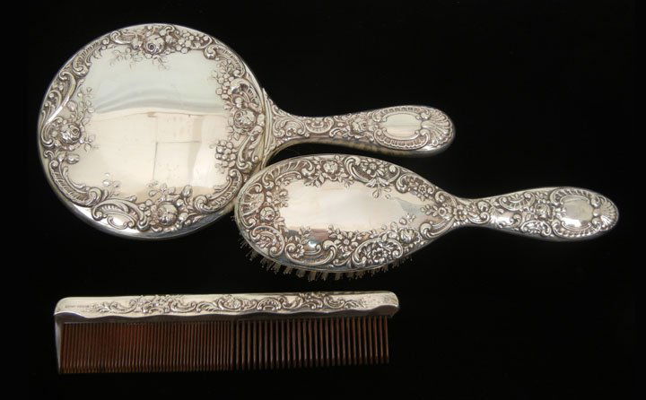 Gorham three piece sterling silver dresser set, re: Gorham three piece sterling silver dresser set, repousse flower pattern, hand mirror measures 10" in length, brush is 8 5/8" long and com is 7 1/2" long, marked Gorham Sterling, mid 20th C.