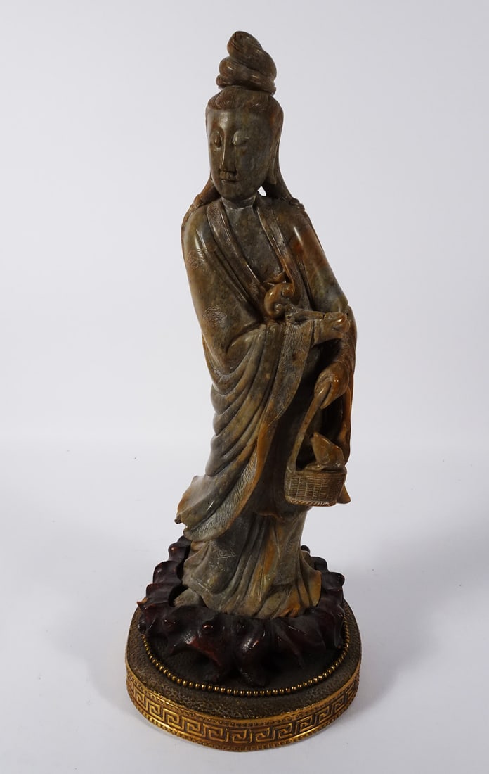 Chinese Carved Soapstone Quanyin Figure: Chinese carved soapstone Quanyin figure, left hand holds a basket that has a fish, right hand holds a scepter like object, mounted onto a wood base and then later mounted onto a brass lamp base, circa