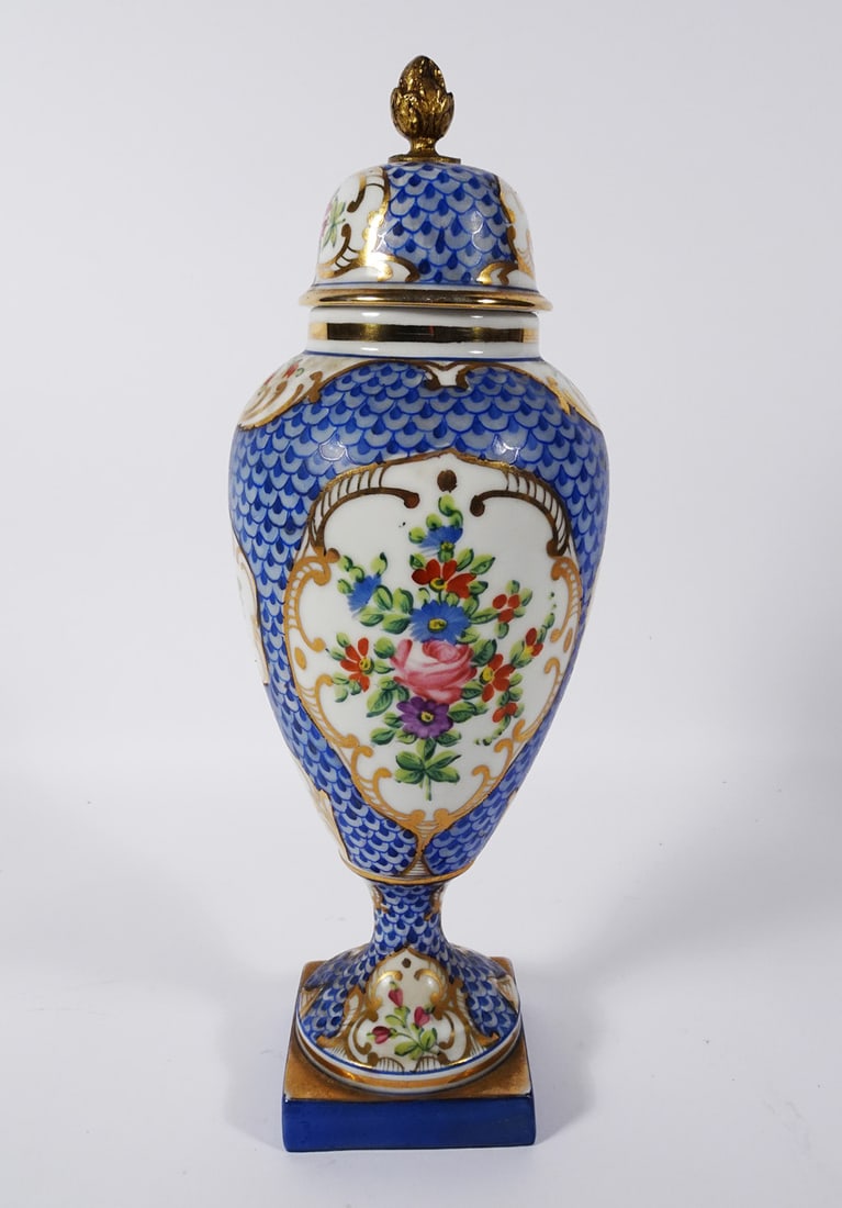 English Porcelain Covered Garniture Urn: English porcelain hand painted covered garniture urn, decorated with a hand painted blue fish scale design and floral designs, bronze finial mount on lid, manufacturer unknown, signed on underside of 
