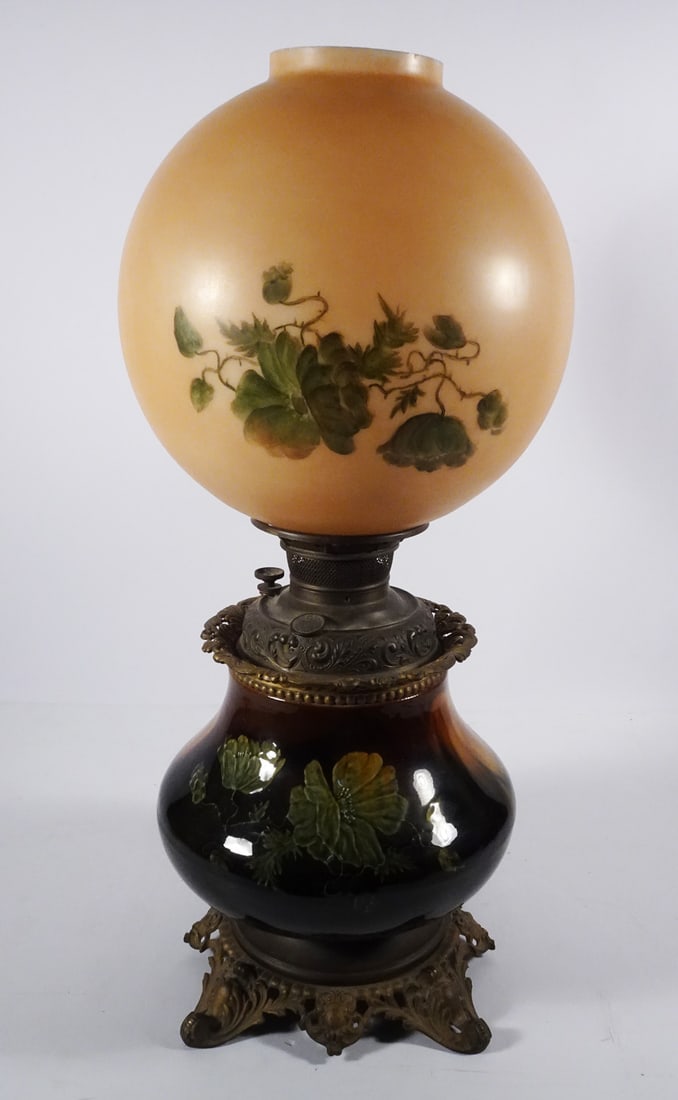 American Art Pottery Oil Lamp: American art pottery oil lamp, unmarked brown standard glaze pottery portion decorated with floral designs, original cast metal fittings and Charles Parker oil font, hand painted glass GWTW style shad