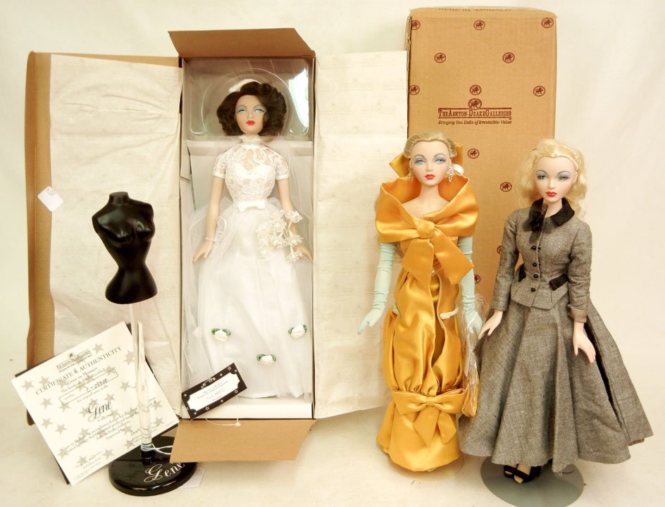 Three Gene dolls by Ashton-Drake and a Gene dress f: Three Gene dolls by Ashton-Drake and a Gene dress form, "Gene in Monaco" in original box with certificate of authenticity and paper string tag, with original packaging box, two dolls in formal clothes