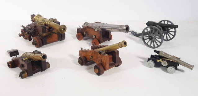 Miniature Black Powder Military Cannons Grouping: Four piece miniature black powder military cannons grouping, all are unmarked, manufacturer unknown, circa early 20th c. to mid 20th c., 2" (h) x 5" x 3" wood carriage w/bronze cannon, 2 1/2" (h) x