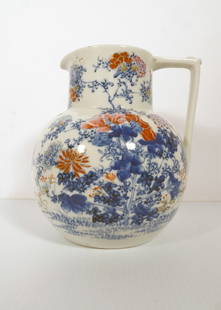 Japanese Arita/Imari Porcelain Pitcher: Japanese Arita/Imari porcelain pitcher, decorated with hand painted multi color floral motifs and a yellow bird, signed on underside of base with blue character marks, circa early 20th c.