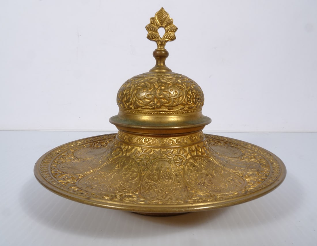 Antique French Brass Inkwell: Antique French brass inkwell, decorated with engraved Persian figures and Arabesque geometrical designs, unmarked, manufacturer unknown, comes with its original white porcelain ink holder, 5" (h) x 5