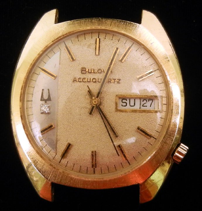 Man's Bulova Accuquartz wristwatch, case measures: Man's Bulova Accuquartz wristwatch, case measures 1 38" in diameter, marked 14K Bulova J960426 N3, small diamond on face, includes original curved pins for band, mid 20th C.