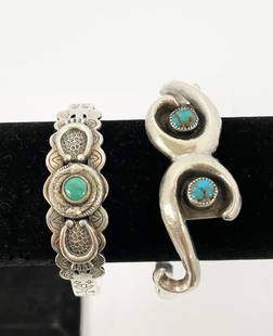 Two Native American Sterling and Turquoise Cuff Bracelets: Two Native American sterling and turquoise cuff bracelets, the first with center turquoise stone and stamped designs of feathers, arrows, X's, etc. 15" wide 14.4 grams, and the second with two