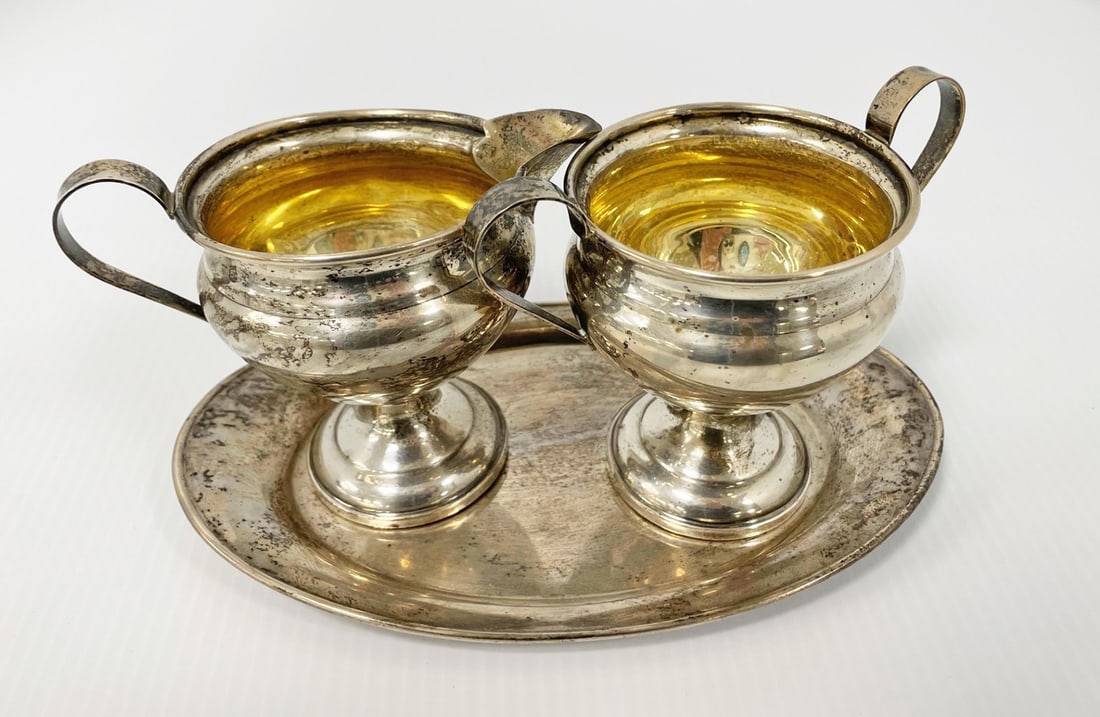 Sterling Silver Creamer and Sugar with Matching Undertray: Sterling silver creamer and sugar with gold wash interiors and sterling silver tray. Creamer 4" high and sugar 4" high are weighted. Tray 8" x 5" weighs 3.620 troy oz.