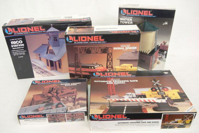 Five Lionel accessories: Water Tower 6-12711 new in box, Operating Automatic Crossing Gate and Signal 6-62162, Operating Signal Bridge 6-12895, Barrel Loader Building 6-12706, and Rico Station Building Kit 6-62709, all mint i