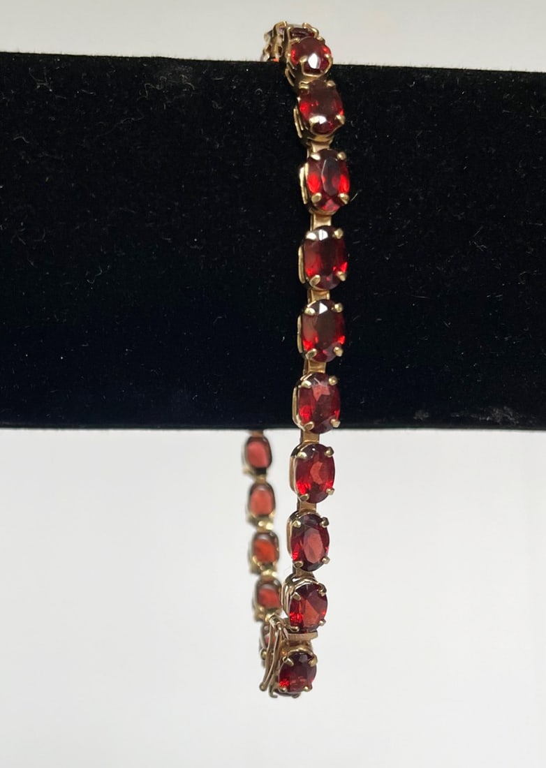10K Gold Garnet Bracelet: 10k gold bracelet with twenty-six 5mm prong set garnets, stamped 10k with maker's stamp, 7", box clasp, 6.3 grams t.w.