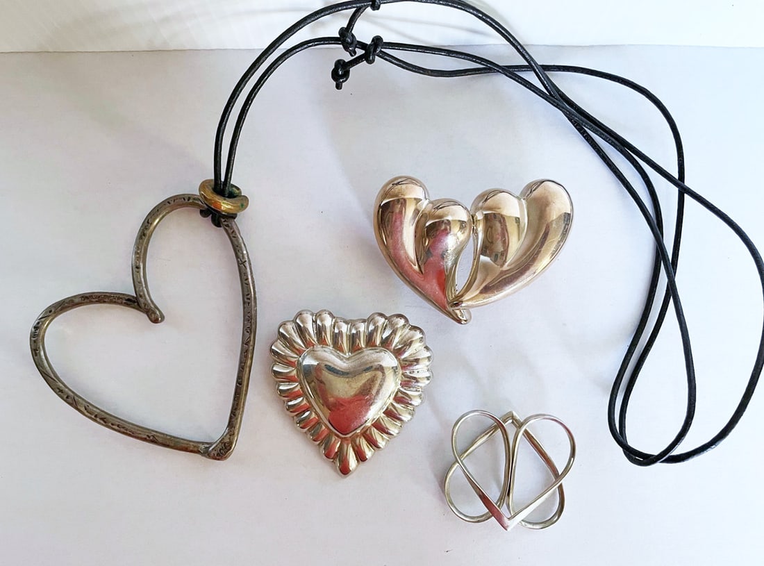 Four Sterling Silver Hearts: Four sterling hearts, the largest on leather cord 3 1/4" x 3" unstamped tests sterling approx. 49 grams; sterling brooch/pendant 2 1/4" x 2 1/4" stamped Mexico 925 with worn maker's stamp 27.8 grams; 