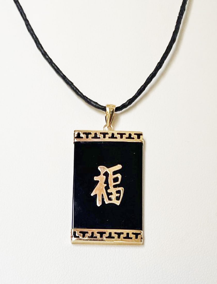Chinese 14k Gold Black Onyx Pendant: Chinese 14k gold black onyx pendant, Chinese good luck symbol in gold overlay on rectangular black onyx, 1 1/4" long x 3/4" wide (without bale), stamped 14k with maker's mark, 18" waxed cord with bras