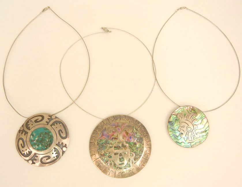 Three Mexican handmade sterling silver pin/pendants wit: Three Mexican handmade sterling silver pin/pendants with neck wires, one 2 7/8" in diameter with abalone inlay and tribal face with headdress, marked Plata 925 Eagle stamp 2; one 2 3/8" in diameter wi