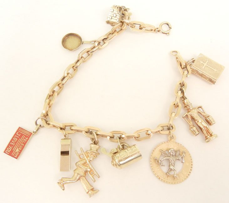 Gold charm bracelet, 18k gold with gold charms includin: Gold charm bracelet, 18k gold with gold charms including chalet, frying pan, enameled telegram "I Love You", whistle, chimney sweep, tankard, Valentine with Cupid, man carrying water and book with cro