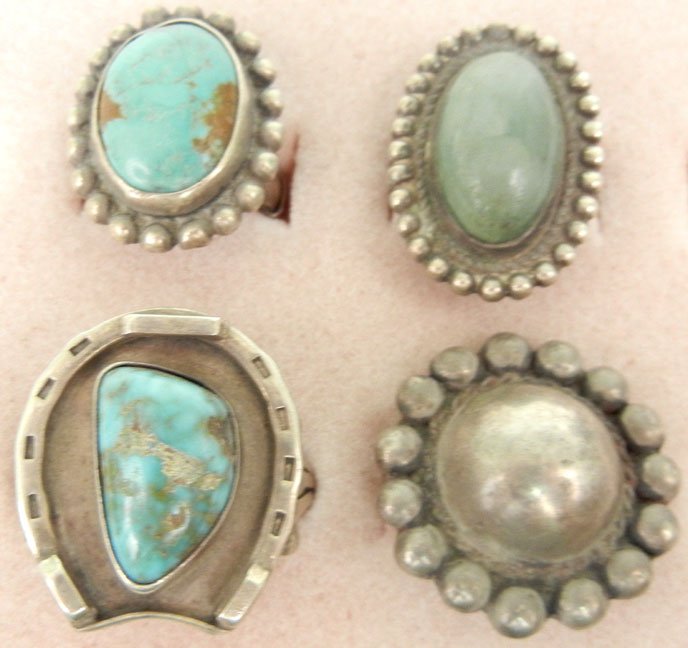 Four handmade sterling silver rings including Native Am: Four handmade sterling silver rings including Native American with turquoise, horseshoe motif, 1" long, size 12; one Native American with oval turquoise, 7/8" long, size 5 1/2; one Mexican with green 