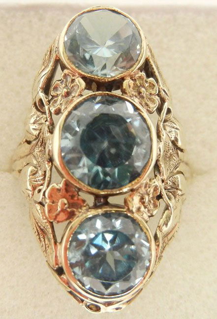 Gold and blue zircon three stone ring, 14k gold mountin: Gold and blue zircon three stone ring, 14k gold mounting with floral motif, center stone measures 7mm in diameter, two stones measuring 6mm in diameter, 1" long, size 4 3/4, marked 14k, weight 3.9 gra