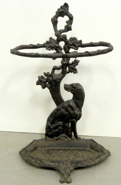 Iron umbrella stand, dog seated by tree, three feet, la: Iron umbrella stand, dog seated by tree, three feet, late 19th C., 27 1/4" x 17" x 14"