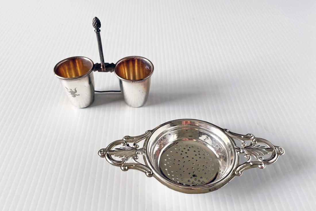Two Sterling Silver Pieces: Webster sterling silver tea strainer 5", and a sterling condiment holder with impressed Prussian eagle on front, both stamped Sterling, 2.670 ozt total weight