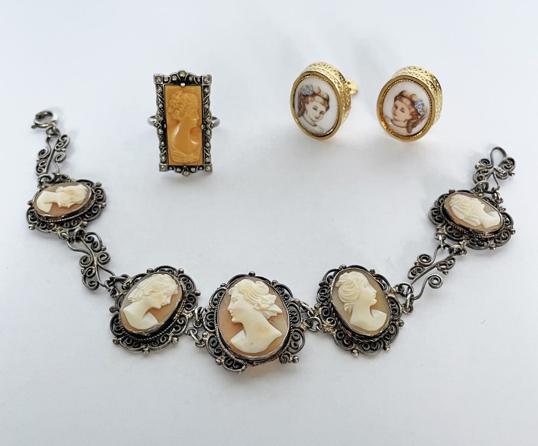 Cameo Jewelry Grouping: Cameo jewelry grouping, includes Art Deco celluloid cameo in silver plated mounting, 1" long, size 6.5; portrait earrings in gold tone metal with clip backs, 7/8" long; and silver filigree bracelet wi
