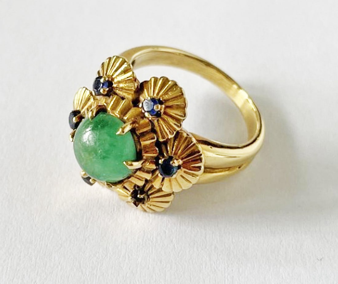 18k Gold Italian Green Stone and Sapphire Ring: 18k gold Italian green stone and sapphire ring, flower motif with round cabochon green hard stone, small sapphires set in to six petals of ring, 3/4" wide, size 7, stamped Italy 18k Verite, weight 8.3