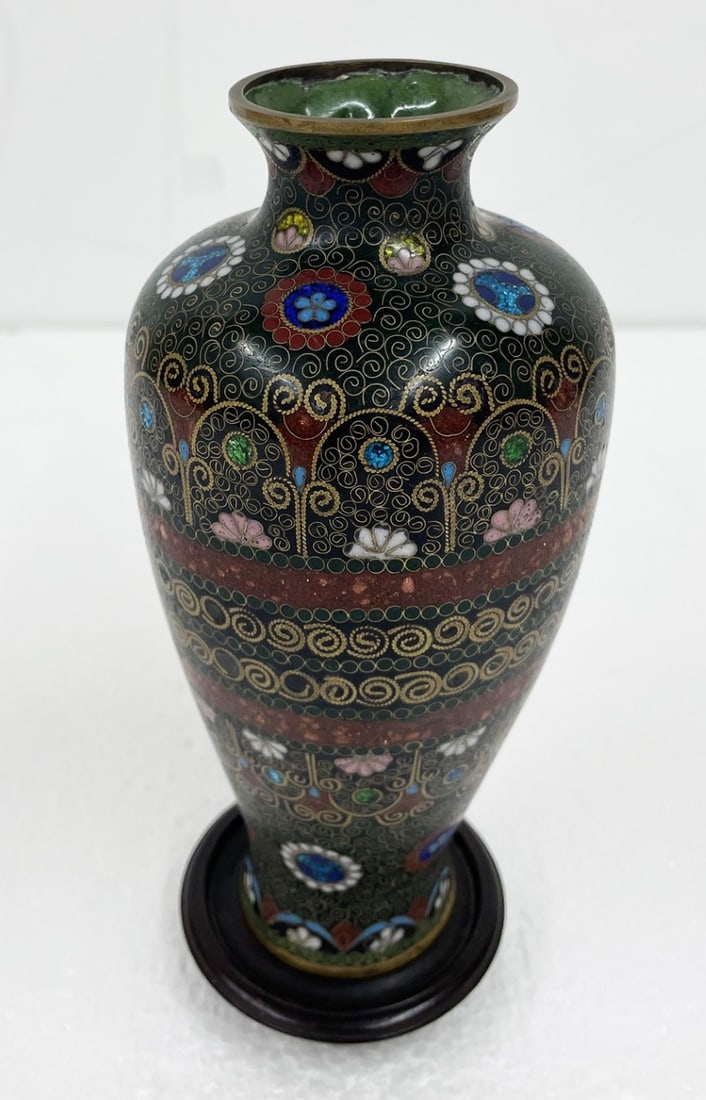 Japanese Cloisonne Enamel Vase: Japanese cloisonne enamel vase, green ground, floral and geometric design, measures 6 3/4" high, with wooden stand
