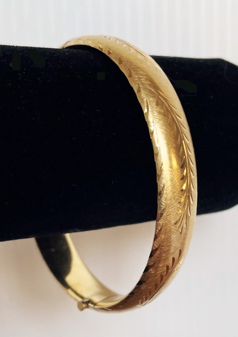Vintage 14k Gold Hinged Bangle Bracelet: Vintage 14k gold hinged bangle bracelet, Florentine finish with engraved leaf design, 6 3/4" inside circumference x 3/8" wide, stamped M 14k, weight 13.7 grams