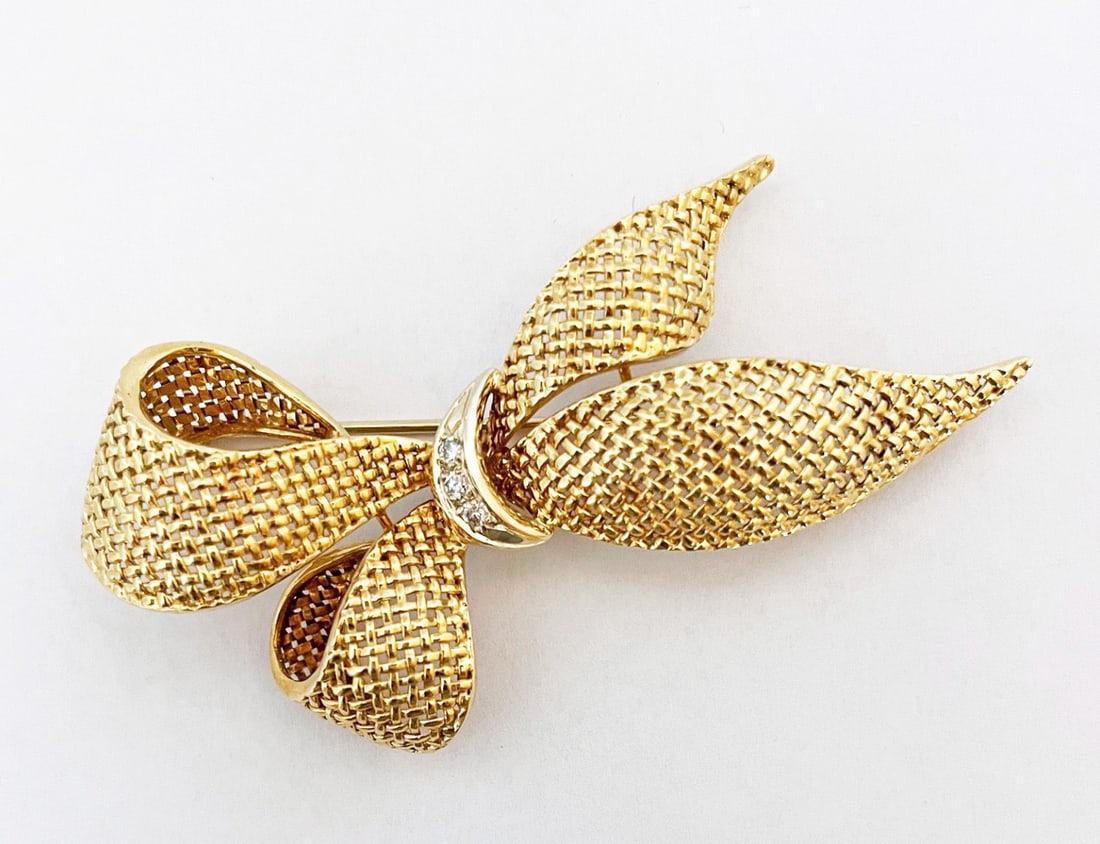 18k Gold Diamond Bow Pin: 18k gold diamond bow pin, three dimensional basket weave design in yellow gold with white gold center, set with three diamonds measuring approximately 0.03 carats each, 0.9 points TCW, brooch measures