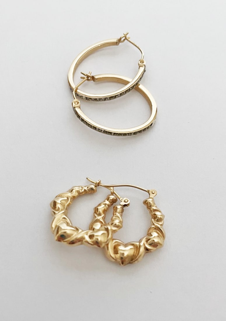 Two Pairs of 14k Gold Hoop Earrings: Two pairs of 14k gold hoop earrings, one pair oval shape and topped with white gold and one small diamond, 1" long, and one smaller pair with repousse hearts, 3/4" long, both stamped 14k, combined wei